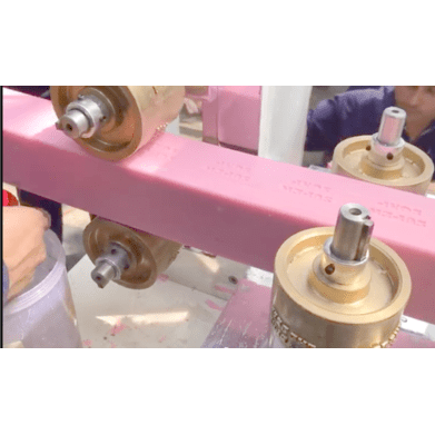 The soap billet exits continuously from the plodder nose cone and moves directly onto the HSB Cutter conveyor, aligned with the extruder outlet.